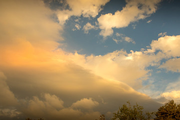 Storm clouds abate after a storm as the sun breaks through image with copy space in landscape format