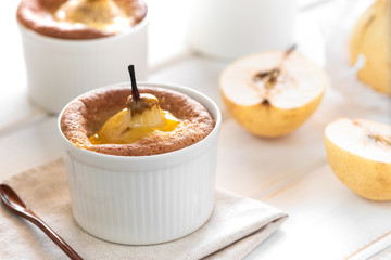Cake with pear in white baking dish on the table.
