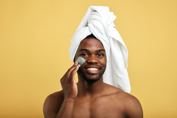 attractive awesome man enjoys cosmetic procedure. close up photo. isolated yellow background. spa, happiness concept.free time, spare time