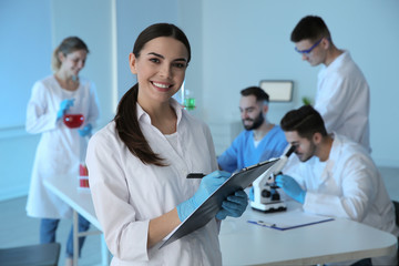 Fototapeta premium Medical student with clipboard in modern scientific laboratory