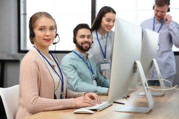 Technical support operator working with colleagues in office