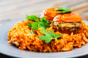 stuffed tomatoes with rice on a white plate