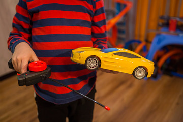 child playing with a wheelchair with a remote at home. radio controlled car toy for children. Boy...