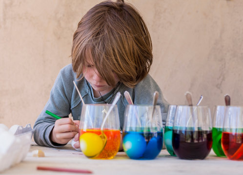 5 year old boy painting easter eggs