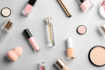 Flat lay composition with bottles of perfume and cosmetics on grey background