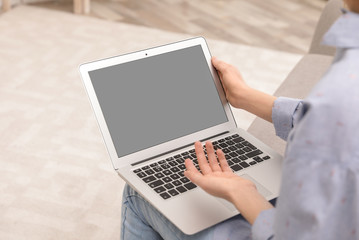 Young woman using video chat on laptop at home, closeup. Space for design