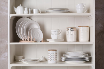 Naklejka na ściany i meble Stylish storage stand with different ceramic dishware at home