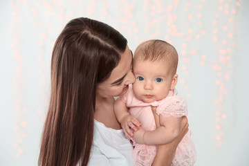 Portrait of happy mother with her baby against blurred lights