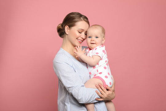 Portrait of happy mother with her baby on color background