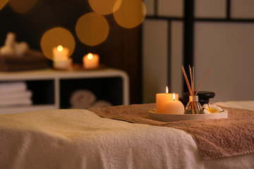 Burning candles and aromatic reed freshener on table in spa salon, space for text - obrazy, fototapety, plakaty