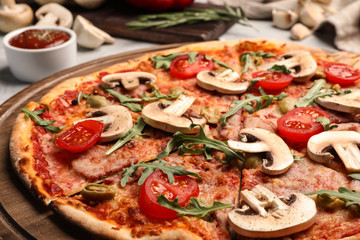 Hot delicious pizza baked in oven on table, closeup