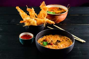 Close up of a bowl of Thai spicy seafood tom yum noodle with shrimp, squid, fish and New Zealand mussel.