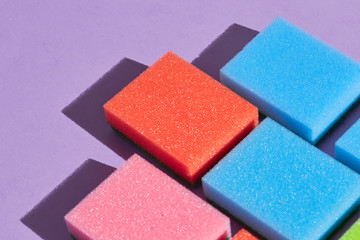 collection of different bright spongers lying next to each other on the table, top view photo, copy space