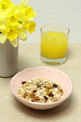 Healthy food: muesli, orange juice, yellow flowers
