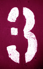 Number 3 in stencil on metal wall in pink tone.
