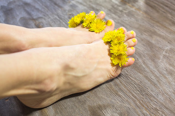 Feet care concept, female feet over wooden background