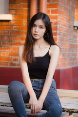 Portrait of thai china adult beautiful girl black shirt blue jeans relax and smile