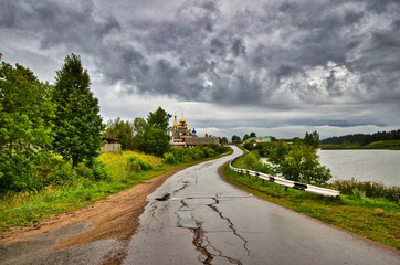 Fototapeta premium Old broken asphalt road in the village with the temple
