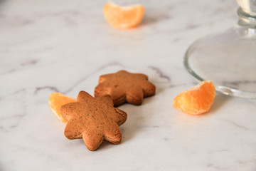 Cookie ginger stars snap on the table with slices of tangerines