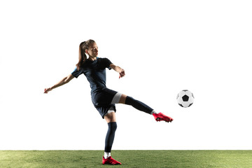 Female soccer player kicking ball isolated over white background