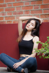Fototapeta premium Portrait of thai china adult beautiful girl black shirt blue jeans relax and smile