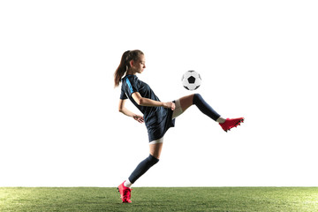 Female soccer player kicking ball isolated over white background