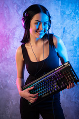 Gamer girl playing with computer at home. Young female posing with computer keyboard.