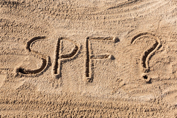 Sun protect factor concept. SPF word written on the beach with question mark