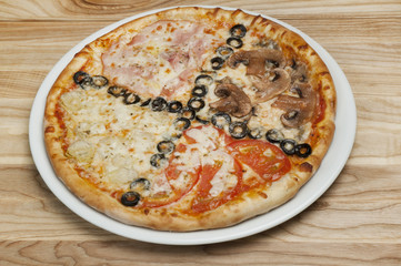 Delicious pizza with cheese, mushrooms, olives and tomatoes on a wood background