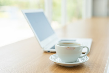 empty cup of coffee with laptop on the table