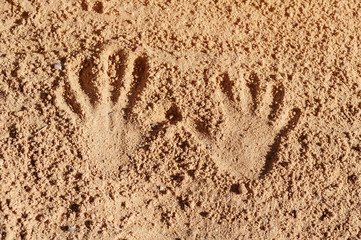handprints on the beach sand