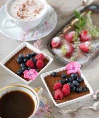 Two cups of coffee, chocolate desserts and strawberries, vintage cutlery