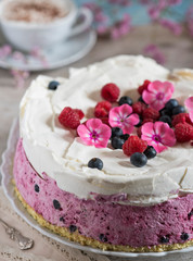 Celebratory cake with berries and a cup of aromatic coffee. Vintage napkin, spoon and pink flowers