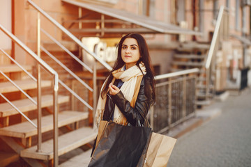 beautiful elegant girl walking around the city with shopping bags