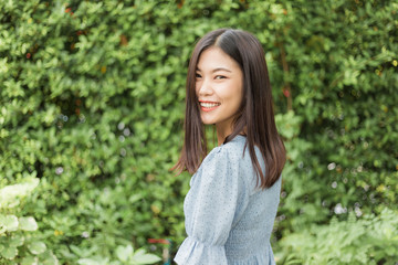 Fototapeta premium Beautiful asain women stand in front of green leaf background