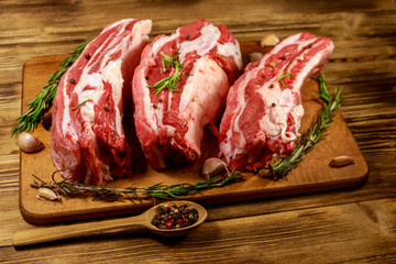 Raw pork ribs with spices, garlic and rosemary on wooden table