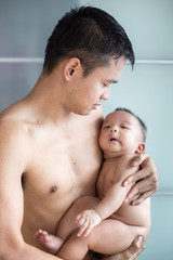 Fototapeta na wymiar Father hold baby boy in hand half nake portrait