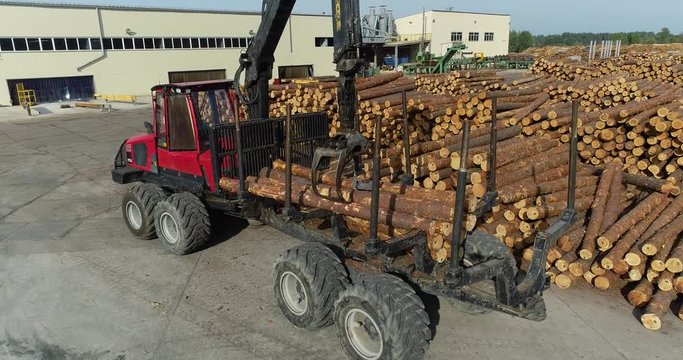 Truck with a manipulator loads logs, Truck for transporting logs with a manipulator. Modern equipment at woodworking factory