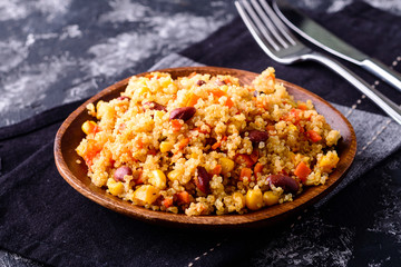 Mexican black bean corn quinoa salad in clay bowl top view, copy space.