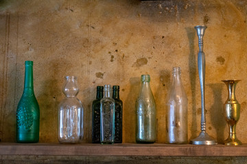 empty glass bottles by the stone wall