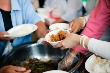 The hands of the rich give food to the hands of the poor : The concept of sharing : Volunteers Share Food to the Poor