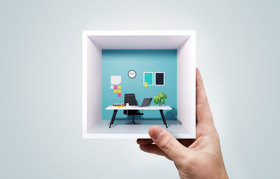 A Man Holding A Miniature Business Office Work Space