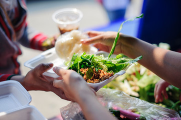 Volunteers Share Food to the Poor to Relieve Hunger : Charity concept : Donate food to hungry people : Concept of poverty and hunger