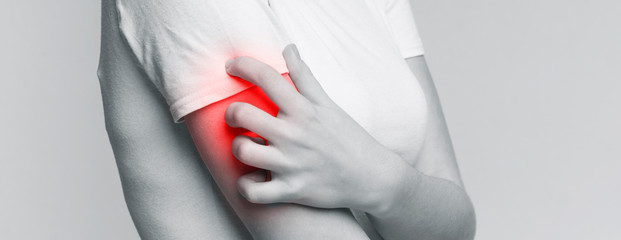Woman scratching her shoulder with red rash