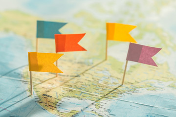 Selective focus of colorful flags and strings on world map