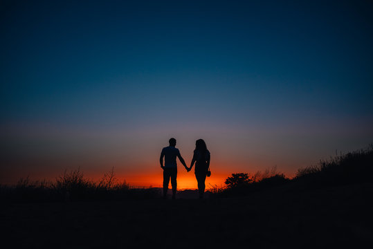 Young couple enjoying sunset in the mountains