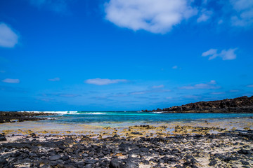 Spain, Lanzarote, Perfect little cove of white sand beach and black lava stones at north coast