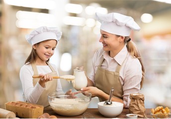 Portrait of adorable little girl and her mother baking together