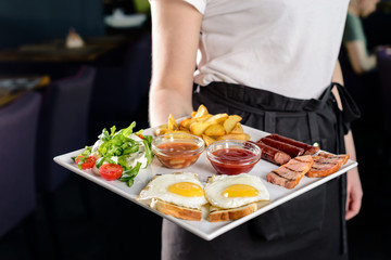 Obraz na płótnie Canvas Waitress serving breakfast at a restaurant