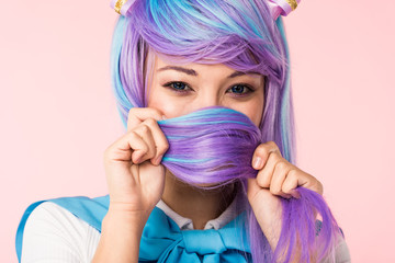 Asian anime girl covering face with hair isolated on pink - obrazy, fototapety, plakaty